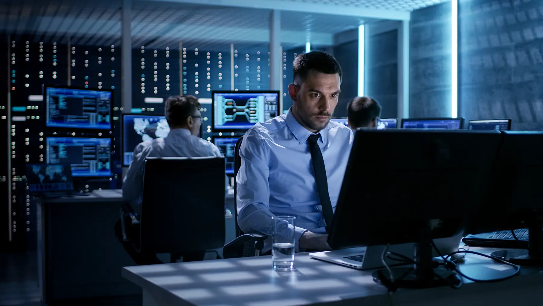 serious IT worker studying data on screen